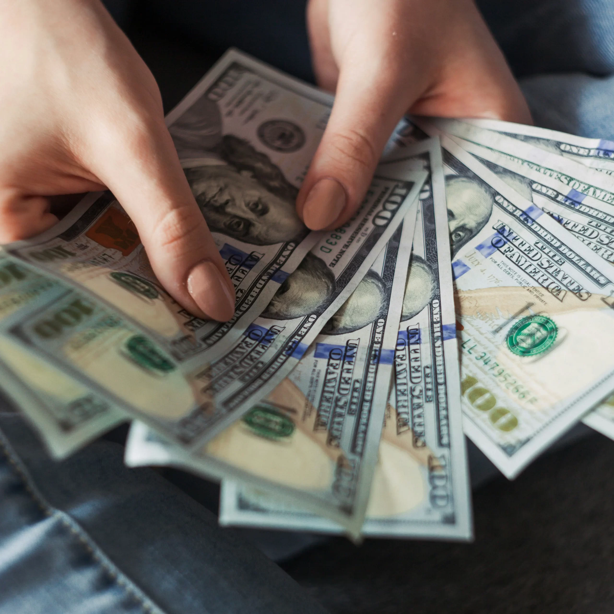 Manos sosteniendo billetes de dólares estadounidenses