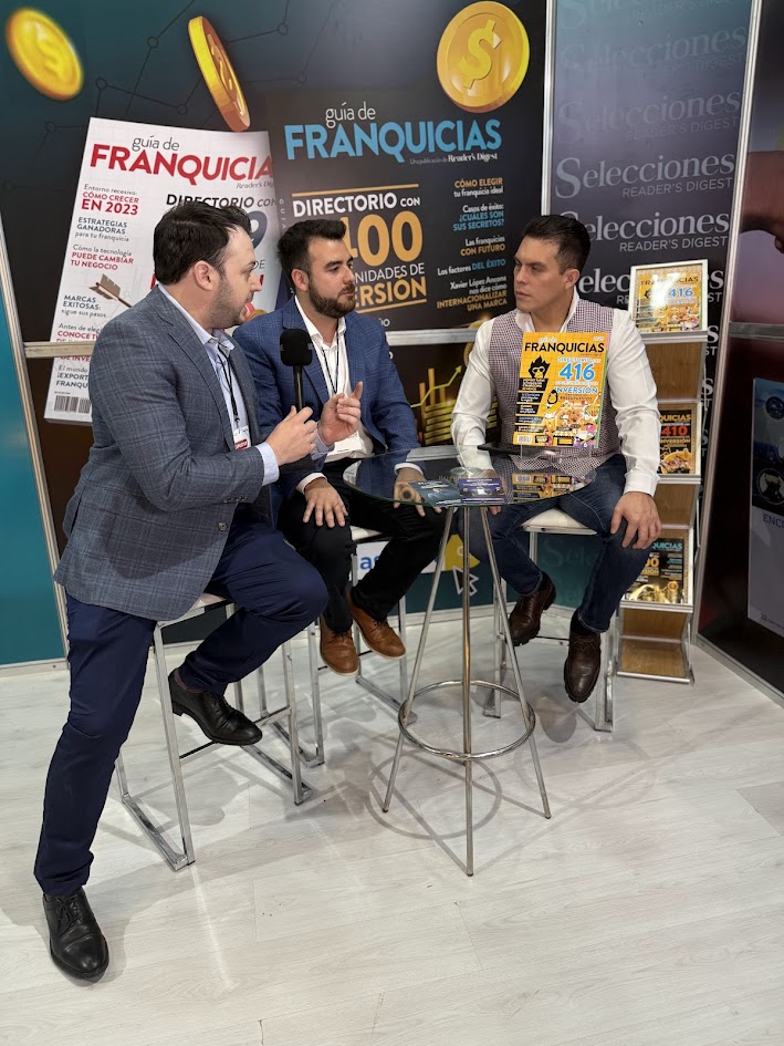 Tres participantes conversan durante una entrevista en un evento de franquicias